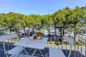 una mesa y sillas en un balcón con aparcamiento en Marriott Cocktail Lake Front Family apartment DesenzanoLoft Official Partner Homes & Villas by Marriott Bonvoy, en Desenzano del Garda