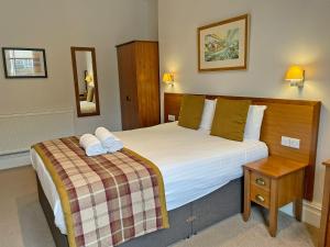 a hotel room with a large bed and a table at The Glengower in Aberystwyth