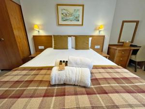 a bedroom with a large bed with two towels on it at The Glengower in Aberystwyth
