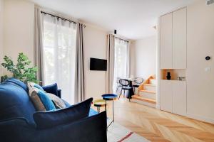 a living room with a blue couch and a table at Lovely Parisian Apartment Near the Eiffel Tower in Paris