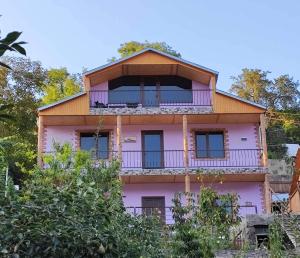a pink house with a balcony on top of it at Violet guest house in Dilijan