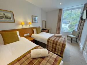 a hotel room with two beds and a window at The Glengower in Aberystwyth