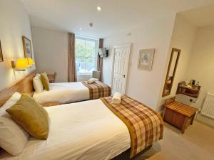 a hotel room with two beds and a window at The Glengower in Aberystwyth