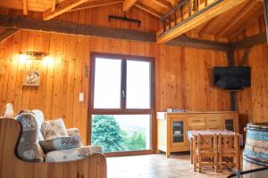 a living room with a couch and a large window at La Grange des Mios in La Bresse