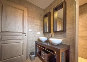 a bathroom with two white sinks on a wooden counter at La Grange des Mios in La Bresse +16 photos