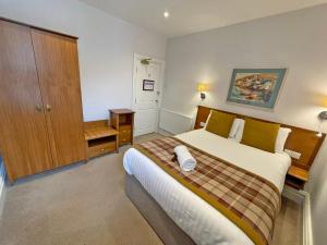 a bedroom with a large bed and a wooden cabinet at The Glengower in Aberystwyth