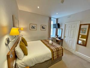 a bedroom with a bed with a lamp and a window at The Glengower in Aberystwyth