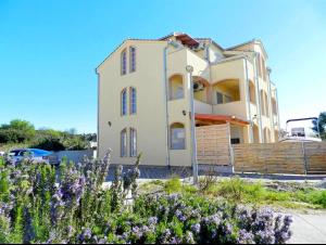 a house with purple flowers in front of it at Apartment Darko in Tribunj