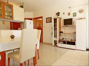 a kitchen and dining room with a table and a refrigerator at Apartment Darko in Tribunj +3 photos