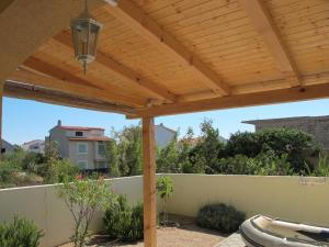 a patio with a wooden pergola at Apartment Darko in Tribunj