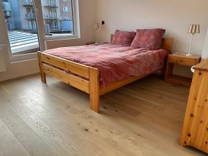 a bedroom with a bed with a red comforter and a window at Louis-Gabriël in De Panne