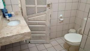 a bathroom with a white toilet and a sink at Seu Refúgio a 100m da Praia do Sobral - Maceió in Maceió +13 photos