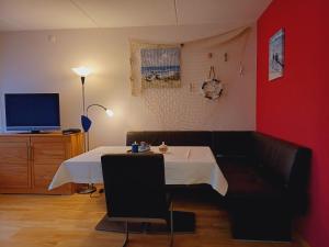 a room with a table and a couch and a tv at Ferienwohnung Seelenbrise in Büsum