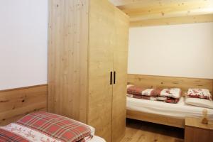 - une chambre avec 2 lits dans une cabane en bois dans l'établissement ALPINE LOFT - Residence Veronza con piscina, Dolomiti Affitti, à Cavalese