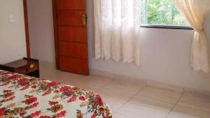 a bedroom with a bed and a window at Chalé Confortável e Completo com piscina in Roças Novas +20 photos