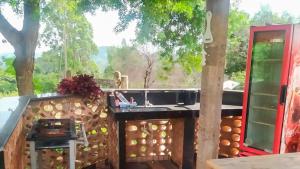 a kitchen with a view of a tree at Chalé Confortável e Completo com piscina in Roças Novas
