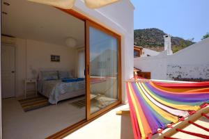 un balcón con una hamaca de arco iris en un dormitorio en Smart Aparts, en Kalkan