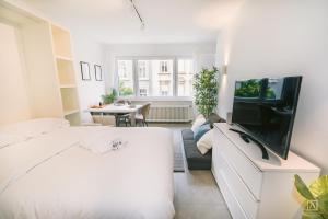 a bedroom with a bed and a tv and a table at Stylish Studio in the Heart of Luxembourg City in Luxembourg