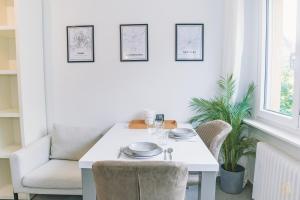 a white dining room with a white table and chairs at Stylish Studio in the Heart of Luxembourg City in Luxembourg +14 photos