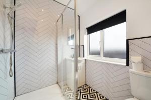 a bathroom with a shower with a toilet and a window at 30 percent off! Elegant Yorkshire Abode - Great Location - Sleeps 19 in Castleford