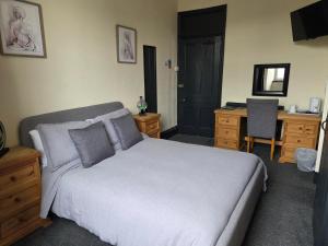 a bedroom with a large bed and a desk and a desk at St aubyn arms Hotel in Praze an Beeble