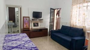 a living room with a blue couch and a tv at Conforto e Espaço para 12 Pessoas em Barueri in Barueri