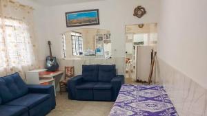 a living room with two blue couches and a kitchen at Conforto e Espaço para 12 Pessoas em Barueri in Barueri