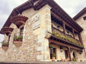 a building with balconies and flower boxes on it at Apartamentos Villa Julieta in Ruente