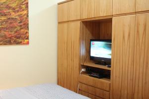 a bedroom with a tv in a wooden cabinet at OKE Apart Hotel in San Lorenzo