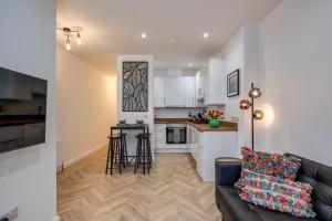 a living room with a couch and a kitchen at Stylish 2 Bedroom Apartment in Belfast in Belfast