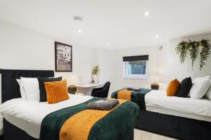 a bedroom with two beds with orange and green sheets at 30 percent off! Elegant Yorkshire Abode - Great Location - Sleeps 19 in Castleford