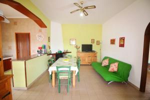 a living room with a table and a green couch at HOMESICILY - Total relaxing in a private property in Floridia
