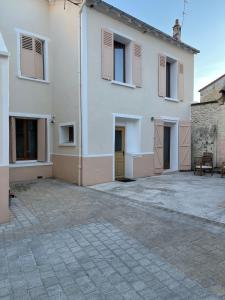 a large white house with a courtyard in front of it at Belle maison à 11 mm des Champs Élysées in Nanterre