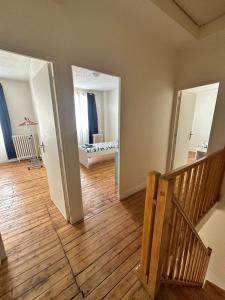 an empty living room with a wooden floor and stairs at Belle maison à 11 mm des Champs Élysées in Nanterre