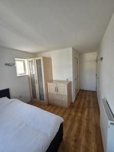 a bedroom with a white bed and a wooden floor at En-suite room LGBTQ friendly in London +5 photos