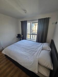 a bedroom with a large bed with a window at En-suite room LGBTQ friendly in London