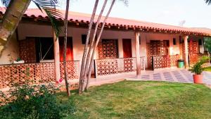 a house with a palm tree in front of it at Chalé Confortável e Completo com piscina in Caeté