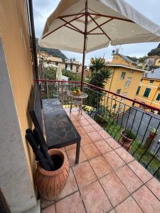 a balcony with a table and an umbrella at La casetta di Tato in Monterosso al Mare