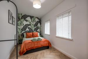 a bedroom with a bed with orange sheets and a mural at Stylish 2 Bedroom Apartment in Belfast in Belfast