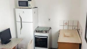 a kitchen with a microwave on top of a refrigerator at Amplo 3 quartos em Barueri in Barueri +11 photos