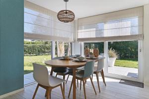 奥德多普Prunus 16 - Klepperstee Ouddorp NOT INTENDED FOR COMPANY OR WORK-RELATED STAYS的配有木桌椅的餐厅