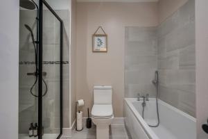 a bathroom with a shower and a toilet and a tub at Stylish 2 Bedroom Apartment in Belfast in Belfast
