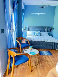 a room with two chairs and a table and a bed at Whispering in Shogi