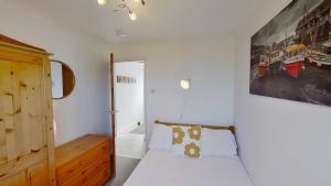 a bedroom with a bed and a painting on the wall at F11 Roslyn, Riviere Towans in Hayle