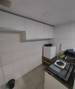 une petite cuisine avec une cuisinière et un micro-ondes dans l'établissement Lindo apart. Terreo recreio dos bandeirantes no Rio de janeiro, à Rio de Janeiro