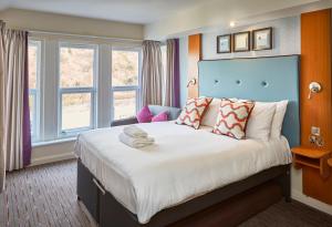 a bedroom with a large bed with a blue headboard at Craigside Manor in Llandudno +58 photos