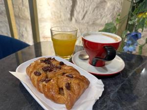 a table with a plate of pastry and a cup of coffee at La Home 1909 in Trani