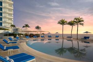 una piscina con palme e un hotel di The Ritz-Carlton, Fort Lauderdale a Fort Lauderdale