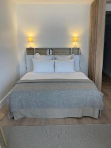 ein Schlafzimmer mit einem großen Bett mit zwei Lampen in der Unterkunft Grand studio hyper centre avec balcon TOUT REFAIT MARS 2025 in Deauville
