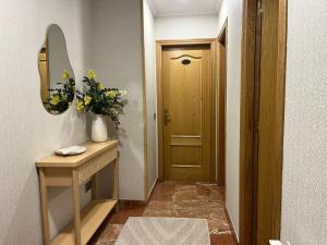 a hallway with a mirror and a wooden door at Caldas no Camiño in Caldas de Reis